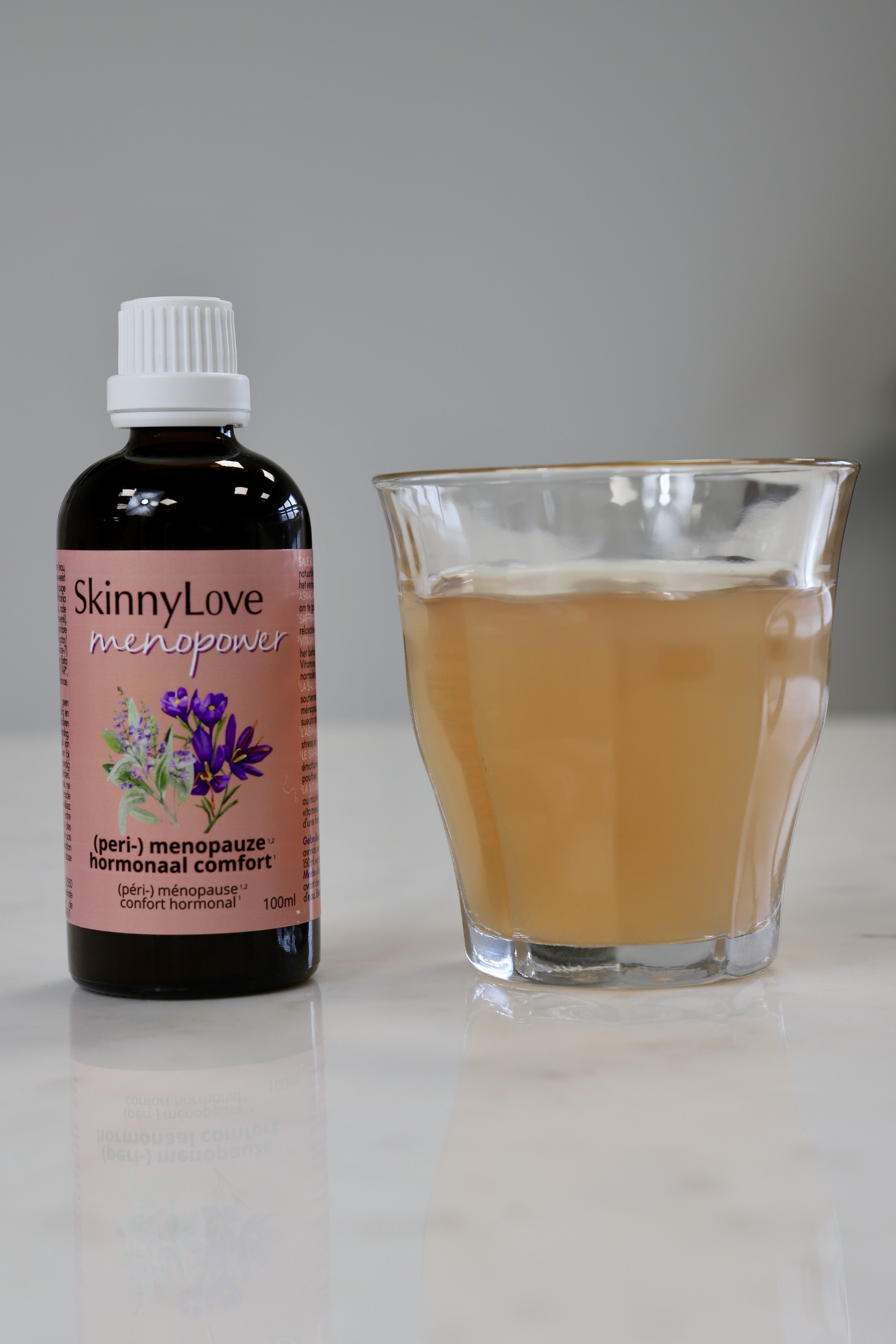 Menopower druppels in glas water